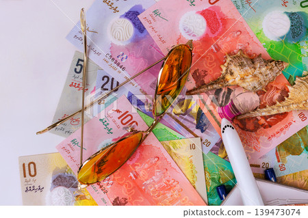 Sunglasses Maldivian rufiyaa money with seashell on table, currency cash summer vibes Sunglasses Maldivian rufiyaa money with seashell on table, currency cash summer vibes 139473074