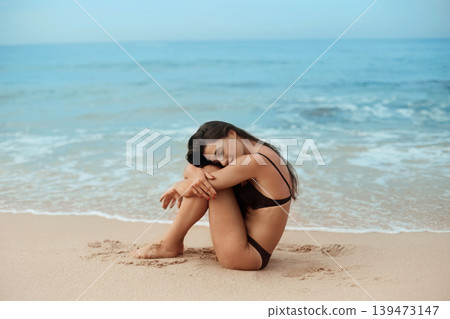 Beautiful woman in swimwear with copy space on the beach. Portrait of pretty girl with slim tanned sexy body in black bikini enjoying life. Summer lifestyle. Vacation Beautiful woman in swimwear with copy space on the beach. Portrait of pretty girl with slim tanned sexy body in black bikini enjoying life. Summer lifestyle. Vacation 139473147