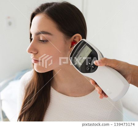 Woman having ear exam. Tympanometry measures the pressure in the middle ear. Impedance audiometry. Woman having ear exam. Tympanometry measures the pressure in the middle ear. Impedance audiometry. 139473174