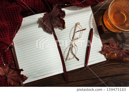 Autumn flat lay with warm tea, open notebook, and fall decorations Autumn flat lay with warm tea, open notebook, and fall decorations 139473183