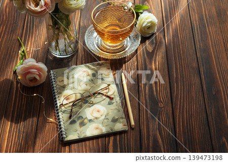 Morning tea, closed notebook, and ranunculus creating inspiring for writing Morning tea, closed notebook, and ranunculus creating inspiring for writing 139473198