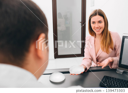 breast augmentation. Young woman holding breast implant breast augmentation. Young woman holding breast implant 139473303