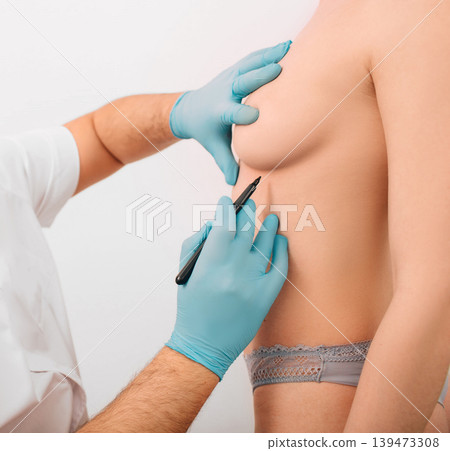 Plastic surgeon marks woman breast for installing breast silicone implant. Cosmetic breast surgery. Plastic surgeon marks woman breast for installing breast silicone implant. Cosmetic breast surgery. 139473308