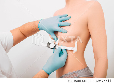 Plastic surgeon marks woman breast for installing breast silicone implant. Cosmetic breast surgery. Plastic surgeon marks woman breast for installing breast silicone implant. Cosmetic breast surgery. 139473311