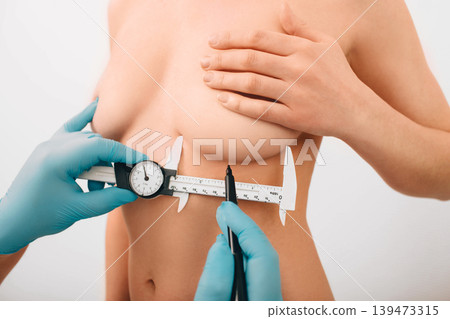 Plastic surgeon marks woman breast for installing breast silicone implant. Cosmetic breast surgery. Plastic surgeon marks woman breast for installing breast silicone implant. Cosmetic breast surgery. 139473315
