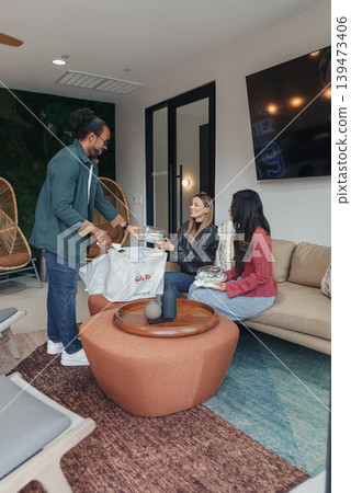 Startup Team Sharing Pizza Living Room, Casual Colleagues Gathered On Sofa Around Low Table, Laughter And Conversation, Warm Lighting, Modern Interior, Cozy Rug, Takeaway Boxes, Informal 139473406