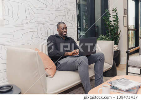 Entrepreneur Relaxing In Stylish Coworking Environment. Business Owner Enjoys Relaxed Atmosphere While Managing Tasks In Modern Coworking Lounge With Plants And Natural Lighting Entrepreneur Relaxing In Stylish Coworking Environment. Business Owner Enjoys Relaxed Atmosphere While Managing Tasks In Modern Coworking Lounge With Plants And Natural Lighting 139473417