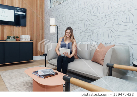 Comfortable Woman Seated In Cozy Lounge. Woman Enjoying Peaceful Reading Session In Reception Area. Relaxed Woman Peacefully Reading While Seated On Sofa In Welcoming Lounge Space Comfortable Woman Seated In Cozy Lounge. Woman Enjoying Peaceful Reading Session In Reception Area. Relaxed Woman Peacefully Reading While Seated On Sofa In Welcoming Lounge Space 139473428