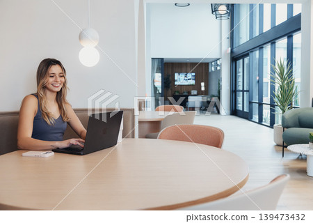 Female Professional Concentrating On Her Computer In Bright Room. Woman Sitting At Round Table Deeply Immersed In Her Laptop Under Natural Morning Light With Serene Decor Female Professional Concentrating On Her Computer In Bright Room. Woman Sitting At Round Table Deeply Immersed In Her Laptop Under Natural Morning Light With Serene Decor 139473432
