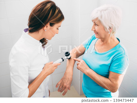 Female dermatologist Inspecting patient skin moles at clinic Female dermatologist Inspecting patient skin moles at clinic 139473447