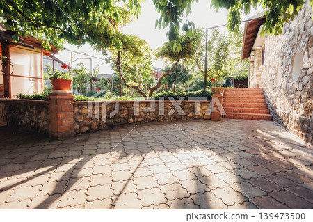 Calm Outdoor Haven. Tranquil Patio With Cozy Ambiance. Serene Openair Area With Textured Walls And Warm Stones. Peaceful Backyard Retreat Featuring Shaded Sunlight And Rustic Textures Calm Outdoor Haven. Tranquil Patio With Cozy Ambiance. Serene Openair Area With Textured Walls And Warm Stones. Peaceful Backyard Retreat Featuring Shaded Sunlight And Rustic Textures 139473500