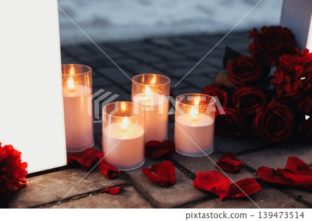 Romantic Candlelit Memorial Scene Glowing Candles, Red Rose Bouquet Beside Glass Votives On Wooden Floor, Scattered Petals And Warm Wax Glows, Evening Vigil Mood, Intimate Solemn Tribute Romantic Candlelit Memorial Scene Glowing Candles, Red Rose Bouquet Beside Glass Votives On Wooden Floor, Scattered Petals And Warm Wax Glows, Evening Vigil Mood, Intimate Solemn Tribute 139473514