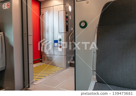 Modern train interior with seat, door connection area and accessibility controls inside passenger carriage. Public transport, railway travel, mobility infrastructure, transportation design, travel Modern train interior with seat, door connection area and accessibility controls inside passenger carriage. Public transport, railway travel, mobility infrastructure, transportation design, travel 139473681