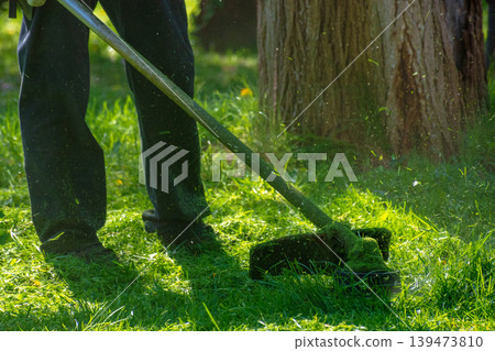 professional garden service at work. lawn care concept. cutting an mowing grass in the park. spring summer season. backlit gardening scene. grass ground view for design 139473810