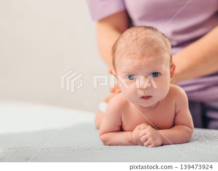 A healthcare provider cares for a newborn baby during a routine examination, ensuring the infant's health and comfort in a clinic setting A healthcare provider cares for a newborn baby during a routine examination, ensuring the infant's health and comfort in a clinic setting 139473924