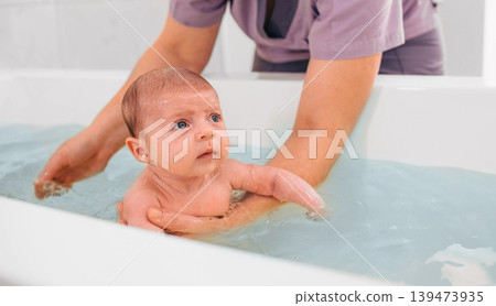 teaches infant baby to swim. Aquatic therapy for infant baby 139473935