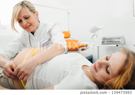 Female doctor measures stomach pregnant. Consultation pregnancy Female doctor measures stomach pregnant. Consultation pregnancy 139473993