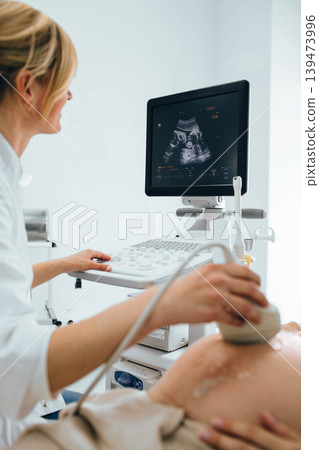 female doctor doing sonogram with pregnant woman at clinic. pregnant patient ultrasound exam 139473996