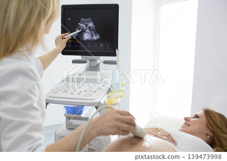 Pregnant woman having sonogram at clinic. pregnant patient ultrasound exam 139473998