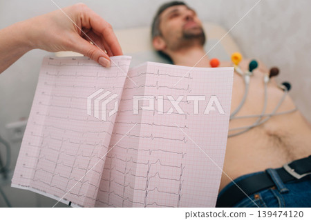 patient getting heart rate monitored at hospital. Close-up Of Ecg Report patient getting heart rate monitored at hospital. Close-up Of Ecg Report 139474120