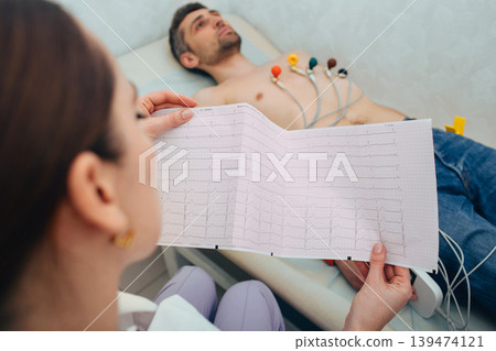 patient getting heart rate monitored at hospital. Close-up Of Ecg Report 139474121
