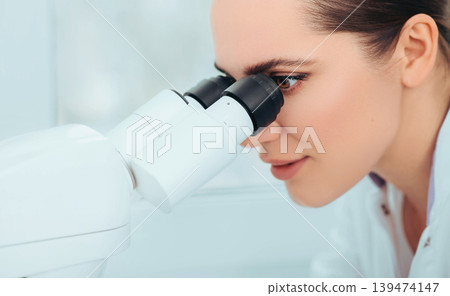 Scientist using microscope in lab, close-up. Laboratory technician while work Scientist using microscope in lab, close-up. Laboratory technician while work 139474147