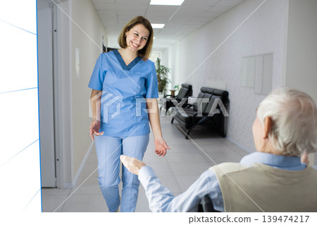 nurse smiling to senior man in wheelchair at nursing home nurse smiling to senior man in wheelchair at nursing home 139474217
