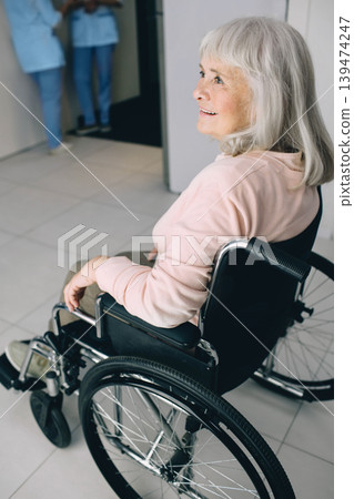 Smiling senior woman in wheelchair sitting at the hospital corridor. Go home after discharge from hospital Smiling senior woman in wheelchair sitting at the hospital corridor. Go home after discharge from hospital 139474247