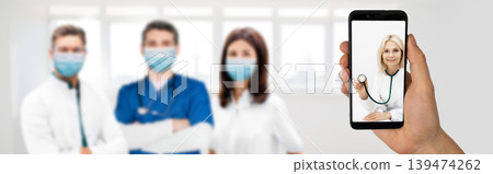 Video calling and online consultation with doctor using smartphone. Team of doctors wearing medical protective masks. Medical support using mobile application Video calling and online consultation with doctor using smartphone. Team of doctors wearing medical protective masks. Medical support using mobile application 139474262
