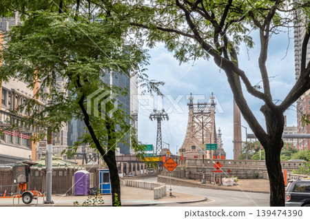 New york, usa august 17,2024. Queensboro bridge connecting manhattan and queens, with the roosevelt island tram tower and city street framed by trees in new york city New york, usa august 17,2024. Queensboro bridge connecting manhattan and queens, with the roosevelt island tram tower and city street framed by trees in new york city 139474390