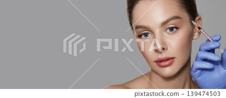 Eye wrinkle injection. Beautiful woman getting eye wrinkle injection for facial rejuvenation and wrinkle removal. Web banner 139474503