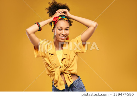 Swarthy lady with African hairstyle and bright hipster clothes having fun and enjoying summer period, on yellow summer background Swarthy lady with African hairstyle and bright hipster clothes having fun and enjoying summer period, on yellow summer background 139474590