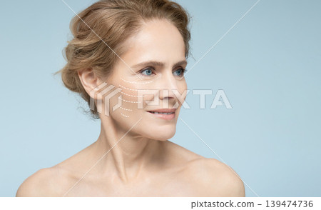 Portrait of beautiful mature woman with perfect skin of face, with arrows on face, concept of lifting skin Portrait of beautiful mature woman with perfect skin of face, with arrows on face, concept of lifting skin 139474736