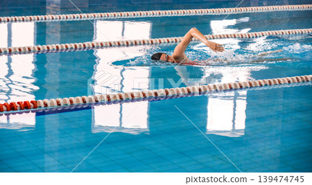 Sports female swimmer swimming in the pool, swimming crawl. Side view, techniques swimming in motion, soft focus 139474745