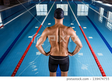 Portrait of smiling man, a swimmer on the rooftop pool. Swimmer in the swimming pool 139474755