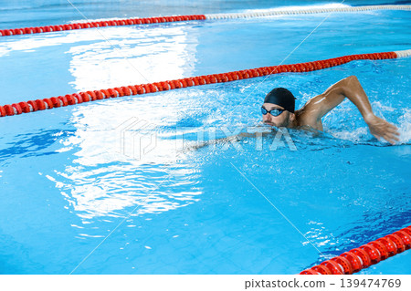 Sports male swimmer swimming in the pool, swimming crawl . Side view, techniques swimming, soft focus 139474769