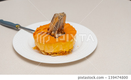 Pumpkin cut in half on a white plate with a knife resting beside it, showcasing the interior and stem, ideal for Halloween decoration and culinary use Pumpkin cut in half on a white plate with a knife resting beside it, showcasing the interior and stem, ideal for Halloween decoration and culinary use 139474800