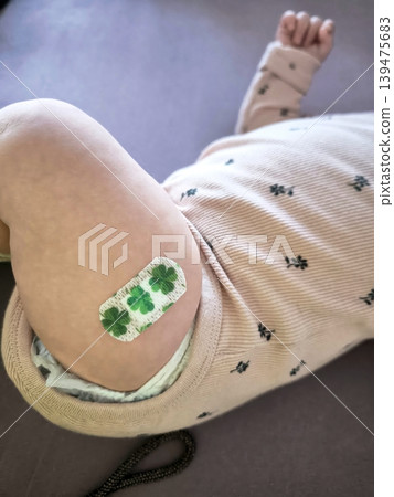 A child's leg with a brightly colored medical plaster after a vaccination. A child's leg with a brightly colored medical plaster after a vaccination. 139475683
