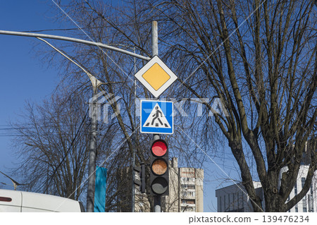 Traffic Lights with Red Light and Road Priority Signs Against Blue Sky Traffic Lights with Red Light and Road Priority Signs Against Blue Sky 139476234