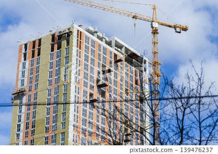 Construction of a Modern High-Rise Apartment Building with a Yellow Crane 139476237