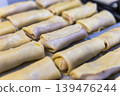 Top View of Many Uncooked Crepe Rolls with Meat Filling on a Tray 139476244