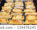 Freshly Baked Golden Crepe Rolls with Meat Filling on a Baking Sheet 139476245