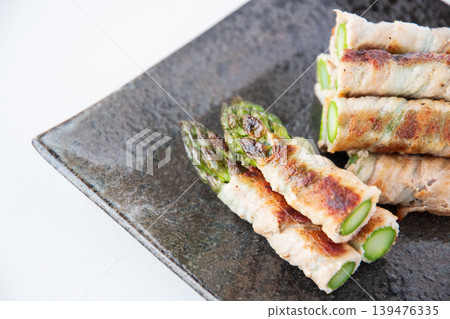 Asparagus wrapped in meat on a plate 139476335
