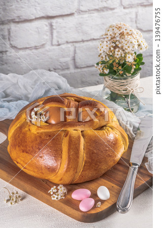 Portuguese traditional Easter cake. Folar with eggs on wooden table Portuguese traditional Easter cake. Folar with eggs on wooden table 139476755