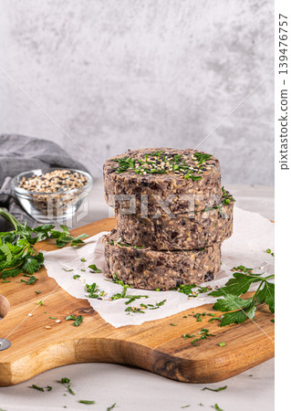 Raw veggie burger with black beans on wood countertop. Raw veggie burger with black beans on wood countertop. 139476757