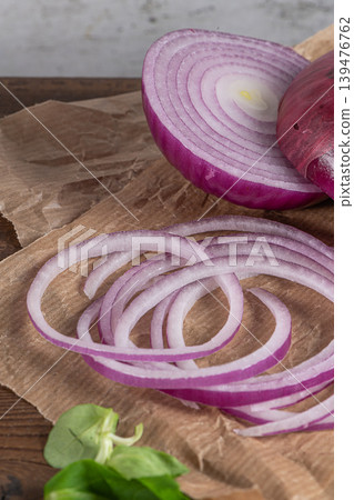 Wooden cutting board on old wooden table top with tablecloth, sliced red onion and cucumber and corn salad Wooden cutting board on old wooden table top with tablecloth, sliced red onion and cucumber and corn salad 139476762