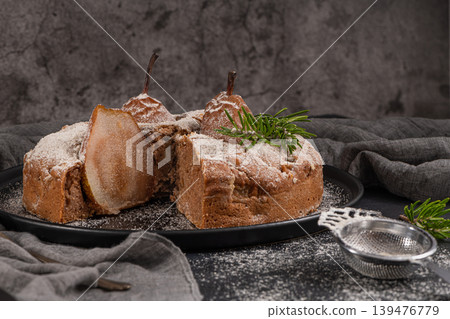 Delicious spice cake with pear, ginger and cinnamon on a dark kitchen counter. Delicious spice cake with pear, ginger and cinnamon on a dark kitchen counter. 139476779