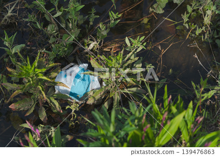 Grass and trash floating on the lake 139476863