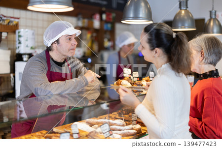 man coffee shop worker offers fresh pastries to customers 139477423