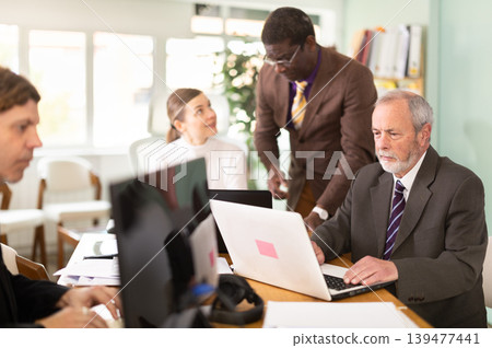 Mature man working in a team in an office Mature man working in a team in an office 139477441